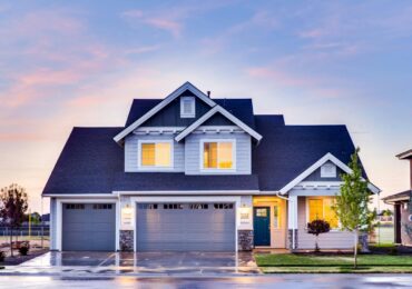 Beautiful two-story house with illuminated windows and garage at dusk.